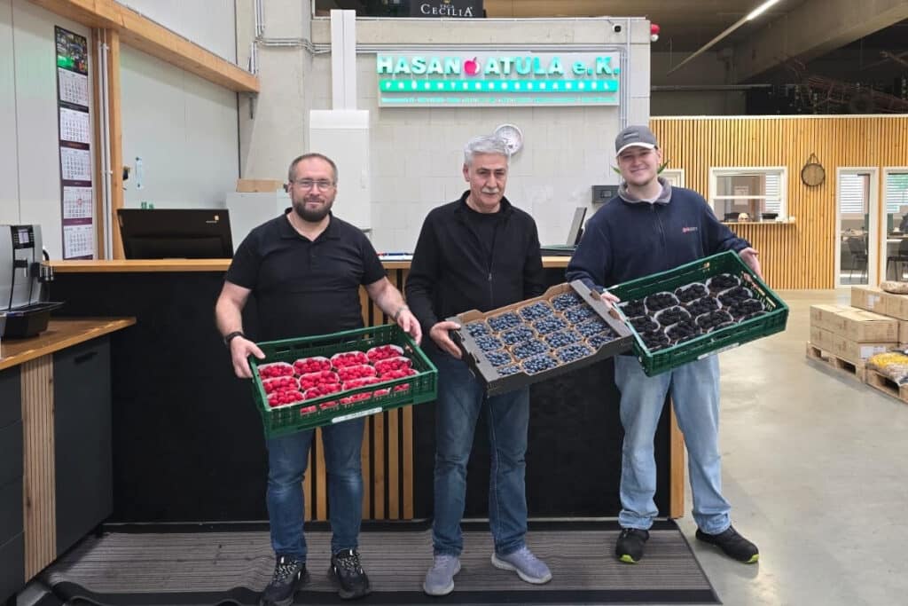 Hasan Atula (Inhaber), Sabahattin Cebba (Verkäufer) und Muhammed Atula (Geschäftsleitung) mit Himbeeren, Blaubeeren und Brombeeren am Tresen in Hilden. Foto: FreshPlaza